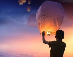 Boy holding up a lit lantern, passion, how to find your passion, joy, purpose