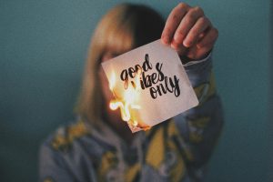 Woman burning a piece of paper that reads "good vibes only," decorative, how to recover from burnout, burnout recovery, burnout